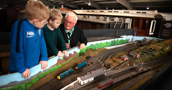 Old man and two children looking at model railway at Locomotion museum